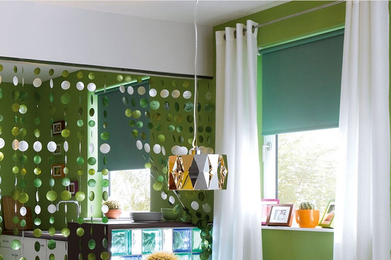 Dekoratives Interieur mit Vorhang aus runden Elementen, Rollo und Lampe