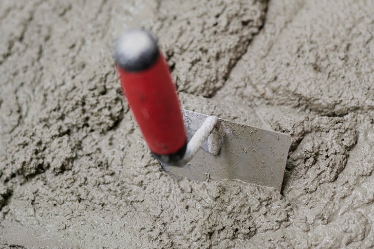 Maurerkelle in feuchtem Zement