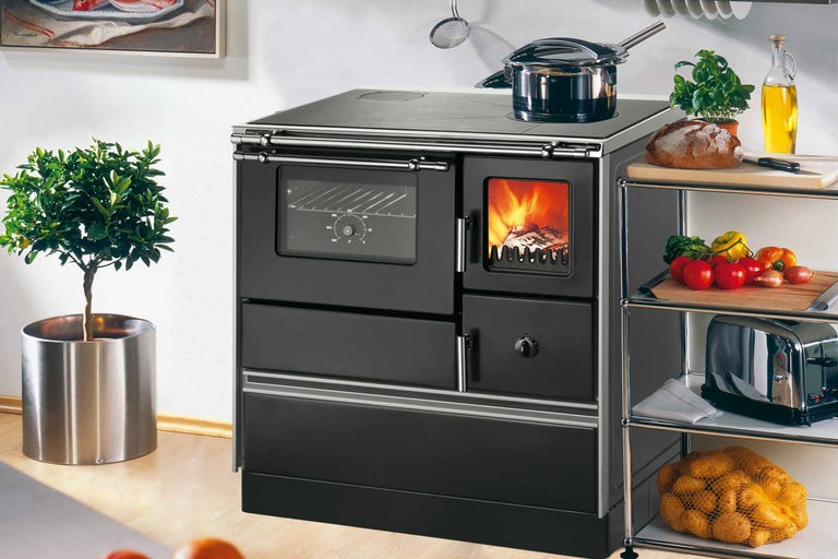 Holzherd in schwarzer Ausführung mit Backofen und Kochfeld in einer Küche.