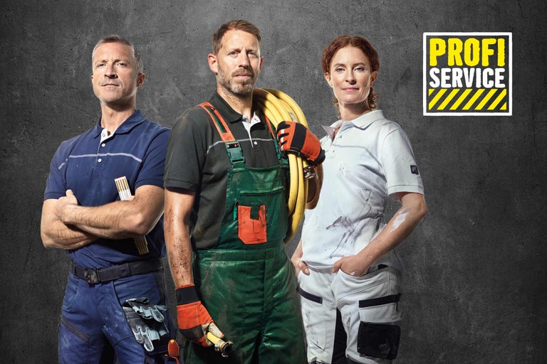 Drei Handwerker vor grauer Wand mit Profi Service Logo. Die Handwerker tragen Arbeitskleidung.