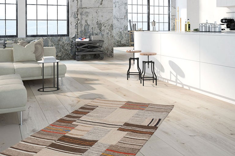 Heller Wohnraum mit Sofa, Teppich und Barhockern