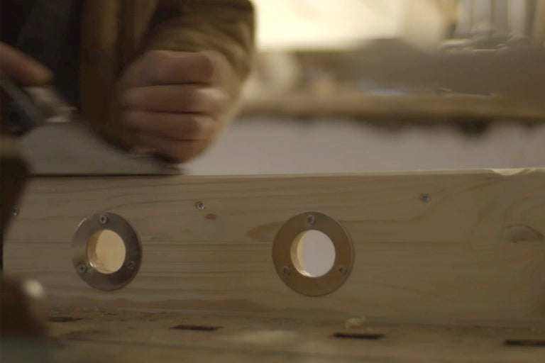 Handhobel bearbeitet Holzbrett mit Bohrlöchern