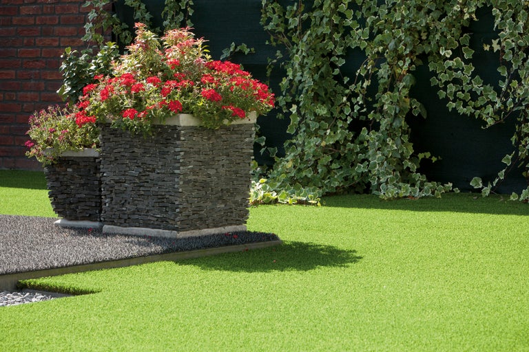 Garten mit Blumenkübeln und Kunstrasen