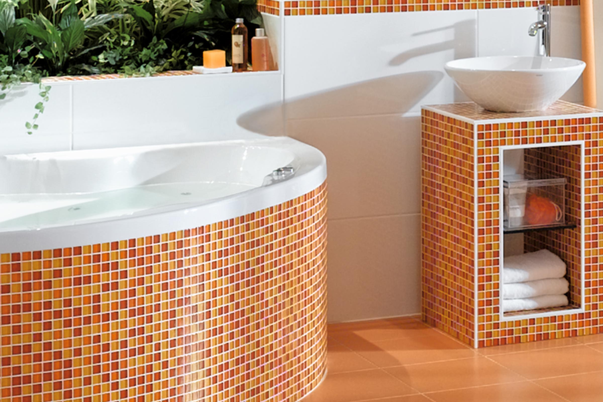 Helles Badezimmer mit Badewanne, Waschbecken und Mosaikfliesen