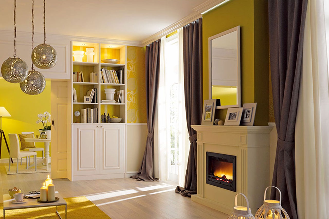 Wohnzimmer mit Kamin, Bücherregal und dekorativen Hängeleuchten