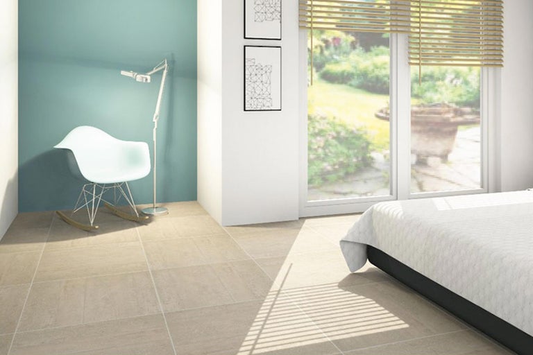 Heller Raum mit Fliesenboden, Schaukelstuhl und Bett