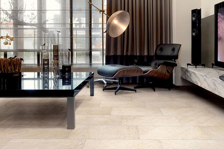 Modernes Wohnzimmer mit Fliesenboden, Tisch, Sessel und Lautsprechern