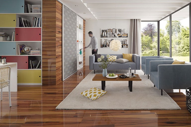 Helles Wohnzimmer mit Holzfußboden, Regalen, Sofa und großem Fenster