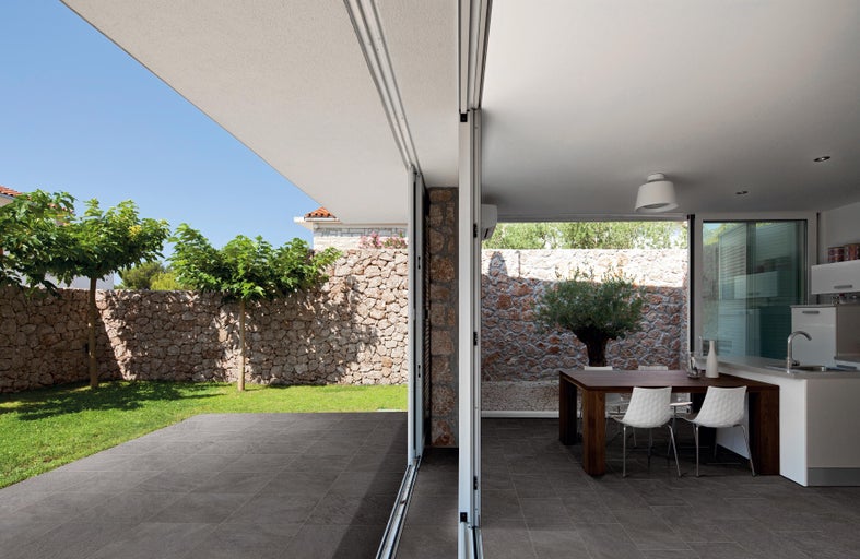 Helle und geräumige Terrasse mit Fliesenboden, Essbereich und Blick in den Garten