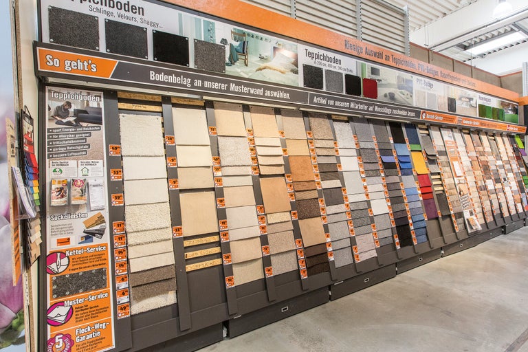 Auswahl an Teppichböden und Bodenbelägen auf einer Musterwand im Hornbach Markt.