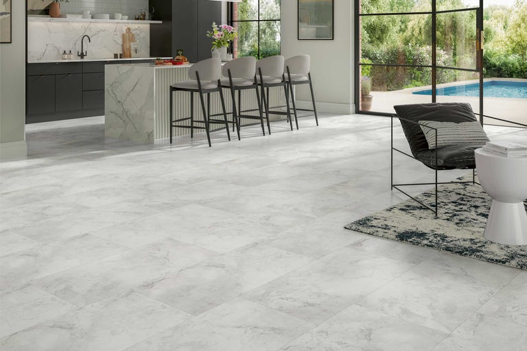 Heller Raum mit Bodenfliesen in Marmoroptik, Kücheninsel und Sitzgelegenheit