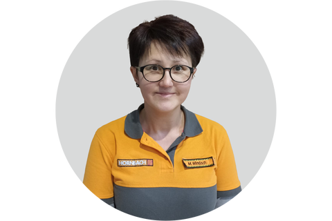 Porträt einer Hornbach Mitarbeiterin mit Hornbach Logo auf dem Poloshirt