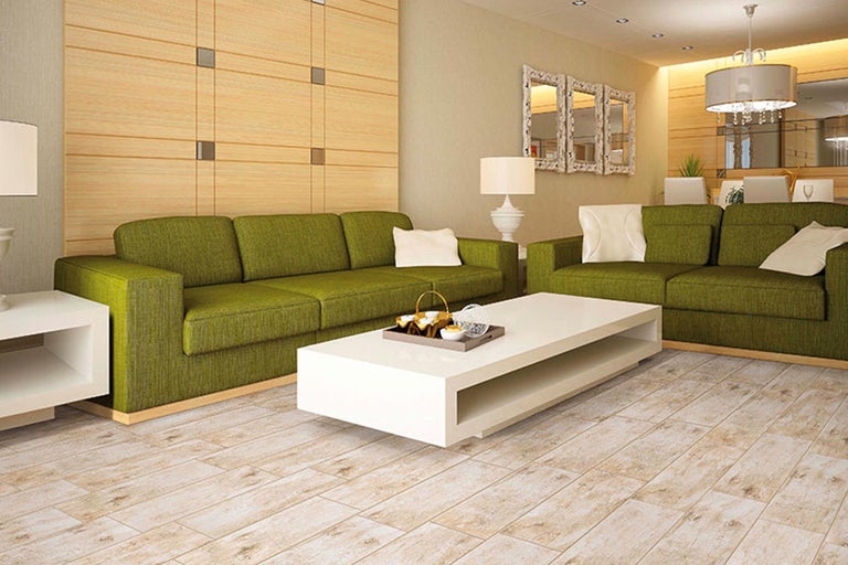 Helles Wohnzimmer mit grüner Couchgarnitur, weißem Couchtisch und Holzboden