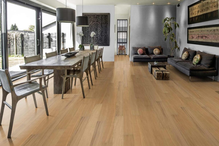 Heller Holzboden in einem Esszimmer mit Esstisch und Stühlen sowie einem Wohnbereich mit Sofas.