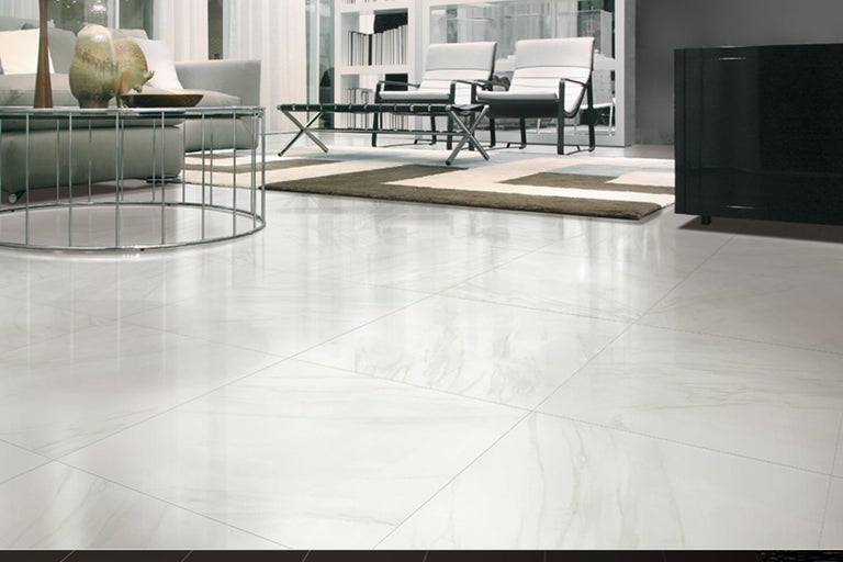 Heller Wohnraum mit Bodenfliesen, Sofa, Couchtisch und Regalen