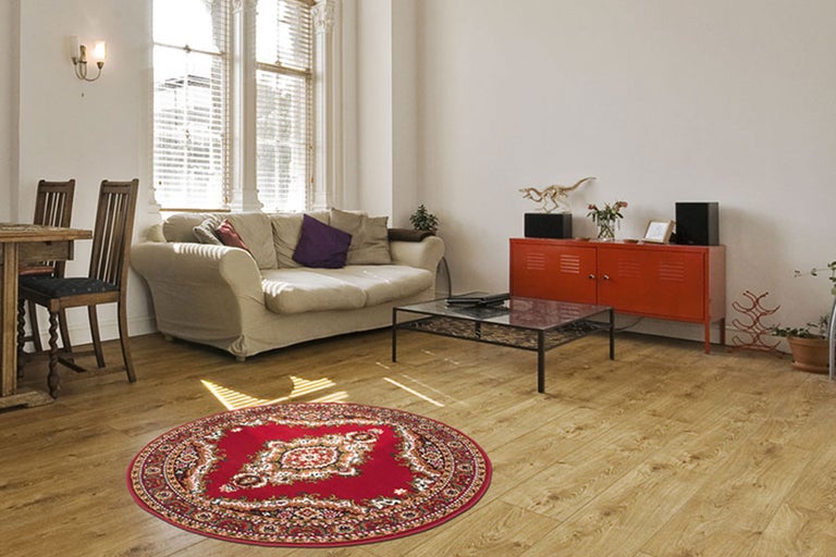 Wohnzimmer mit Sofa, Tisch und rundem Teppich mit Muster