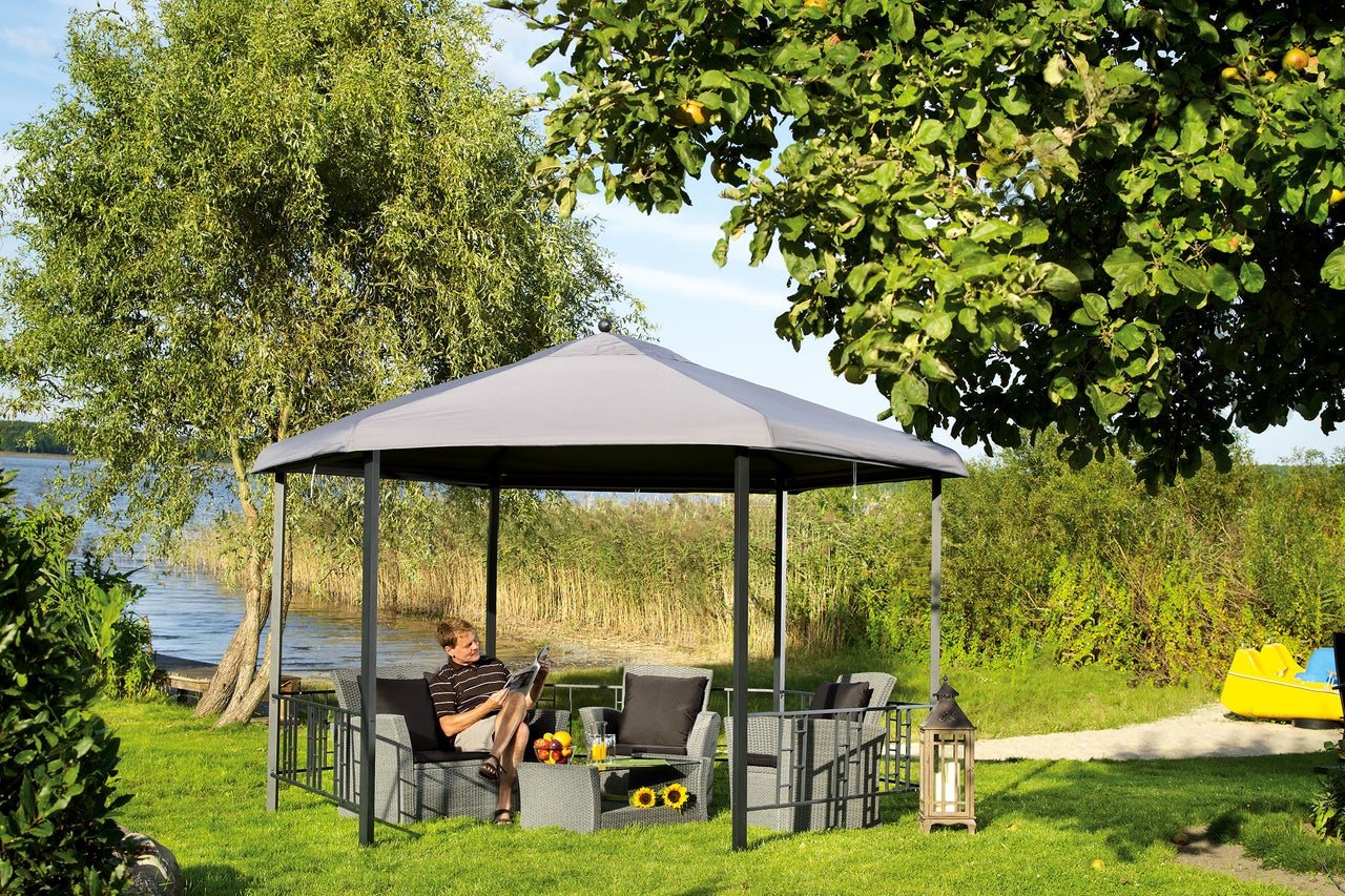 Gartenlandschaft mit Pavillon und sitzendem Mann auf einer Rattansitzgruppe