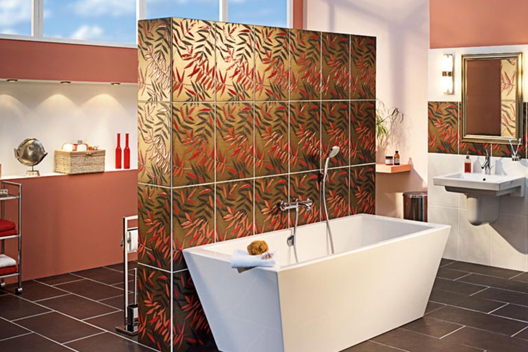 Badezimmer mit Badewanne, Waschbecken und gefliester Trennwand mit Blattmuster