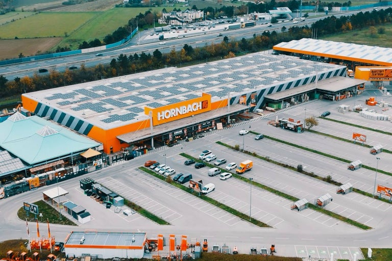 Luftaufnahme eines Hornbach Baumarktes mit Parkplatz und Solaranlage auf dem Dach.