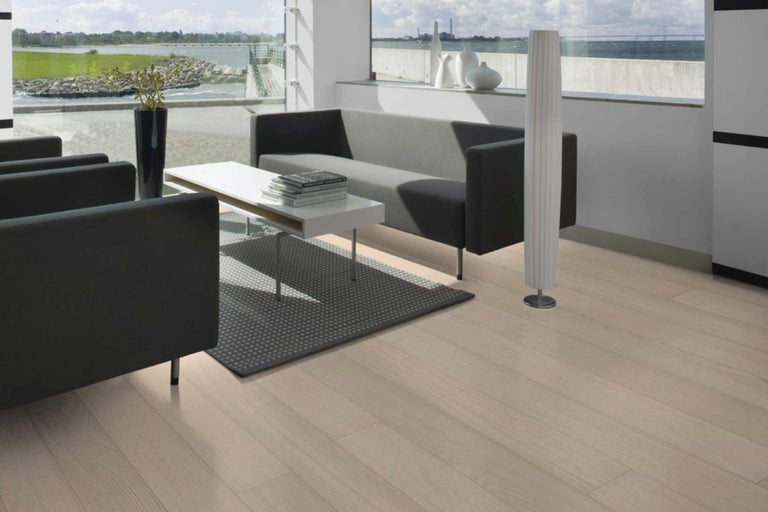 Heller Wohnraum mit Laminatboden, Sofa und Sesseln für ein modernes Ambiente.