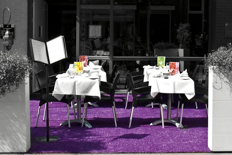 Außenbereich eines Restaurants mit Tischen, Stühlen und Speisekarten