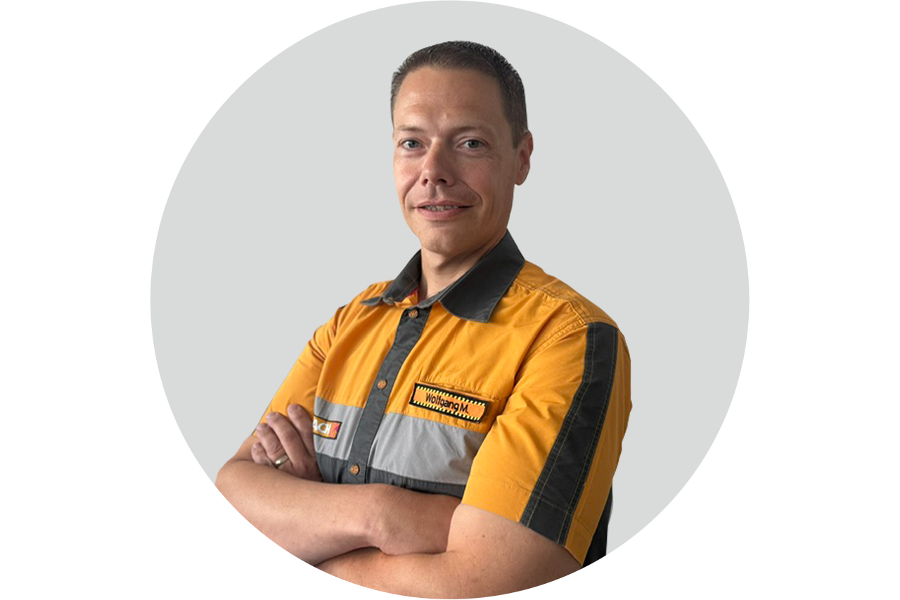 Porträt eines Hornbach Mitarbeiters in Arbeitskleidung mit verschränkten Armen.