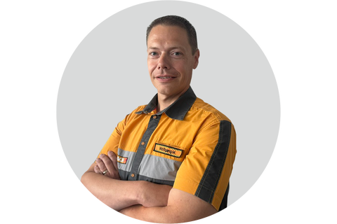 Porträt eines Hornbach Mitarbeiters in Arbeitskleidung mit verschränkten Armen.