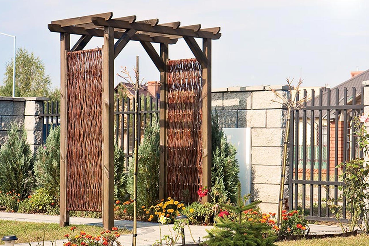 Holzpergola mit Flechtwand im Garten
