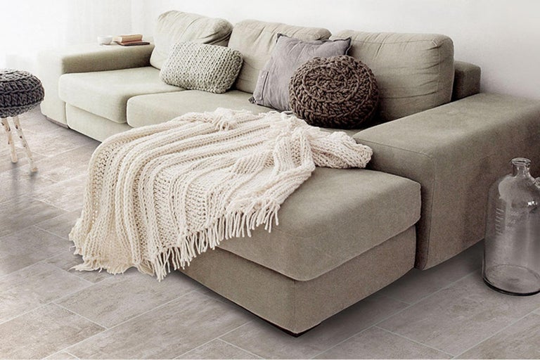 Wohnzimmer mit Sofa, Kissen und Decke