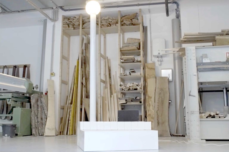 Helles Atelier mit Holzlagern und einer Stehlampe