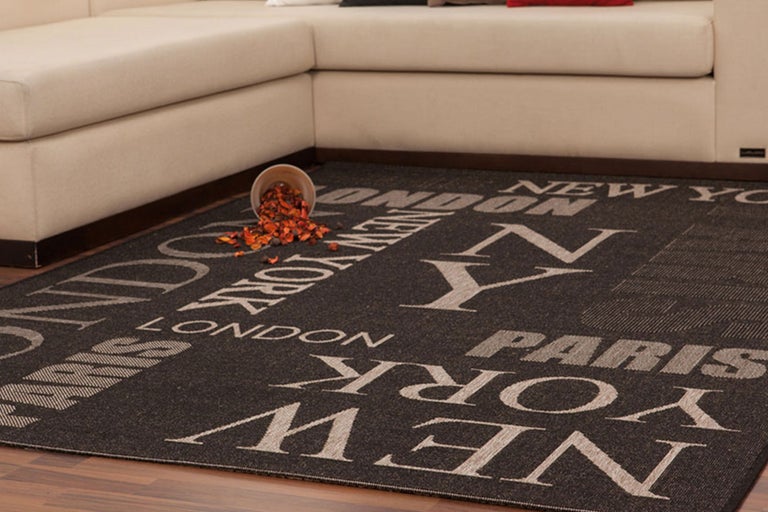 Teppich mit Städtenamen und Sofa im Wohnzimmer