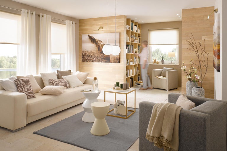Helles Wohnzimmer mit Sofa, Sesseln, Regalen und Dekorationen für ein gemütliches Ambiente
