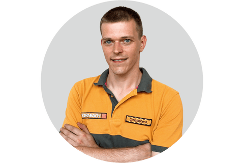 Hornbach Mitarbeiter Christopher K. im Porträt mit verschränkten Armen.