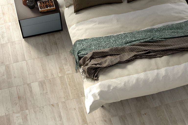 Helles Schlafzimmer mit Holzbodenfliesen, Bett und Nachttisch