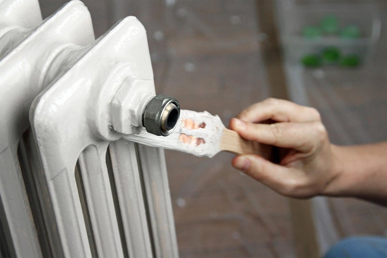 Anstreichen eines Heizkörpers mit einem Pinsel