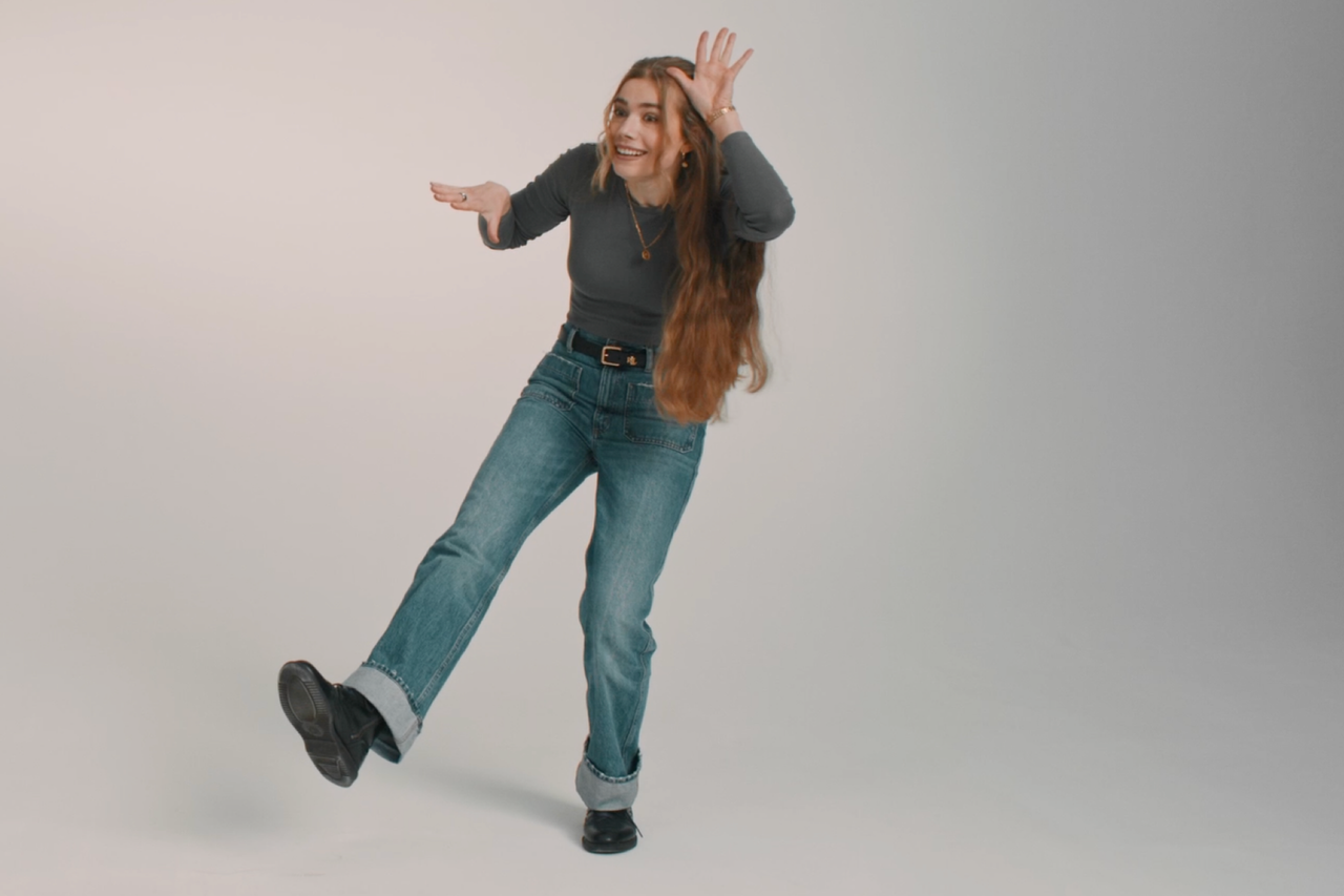 Frau mit langem Haar in Jeans und Oberteil