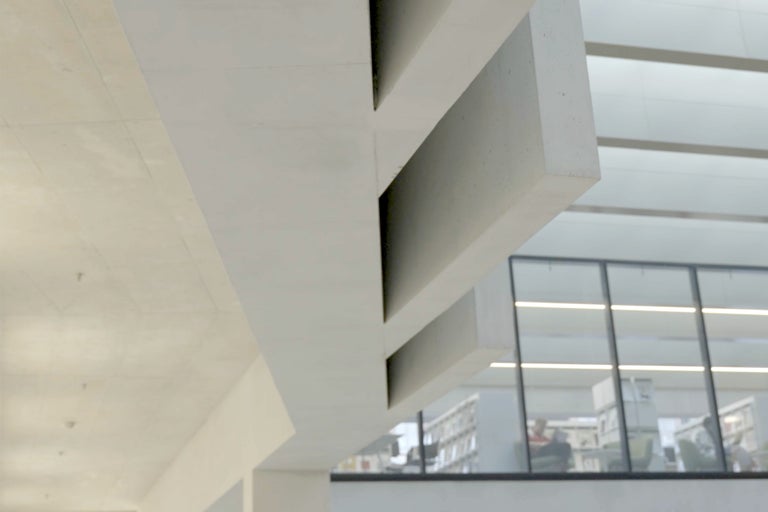 Innenansicht eines Gebäudes mit Betonstruktur und Fensterfront.