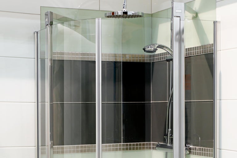 Eckdusche mit Duschkopf und Handbrause in einem modern gestalteten Badezimmer
