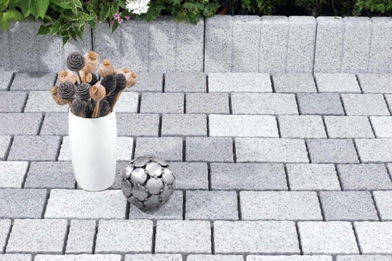 Verlegung von Betonpflastersteinen im Außenbereich mit Dekoration