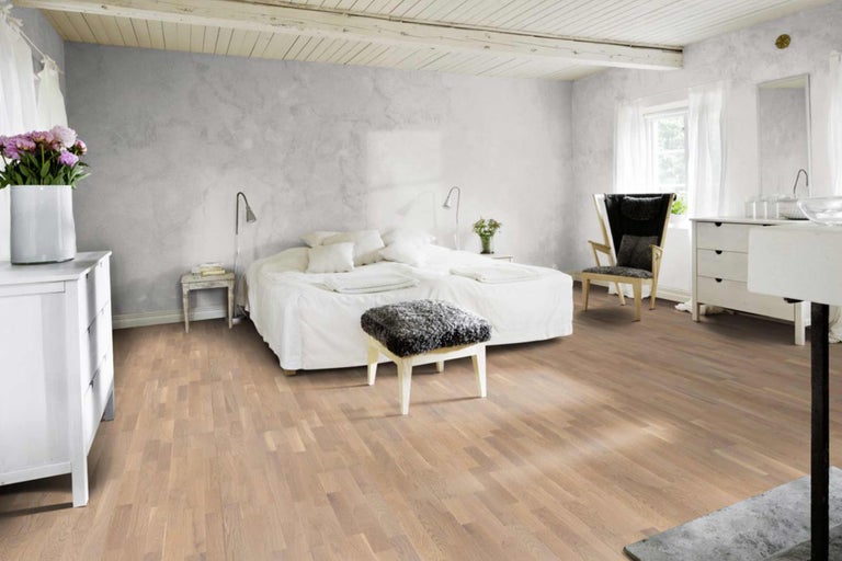 Schlafzimmer mit Holzboden, Doppelbett und Nachttischen