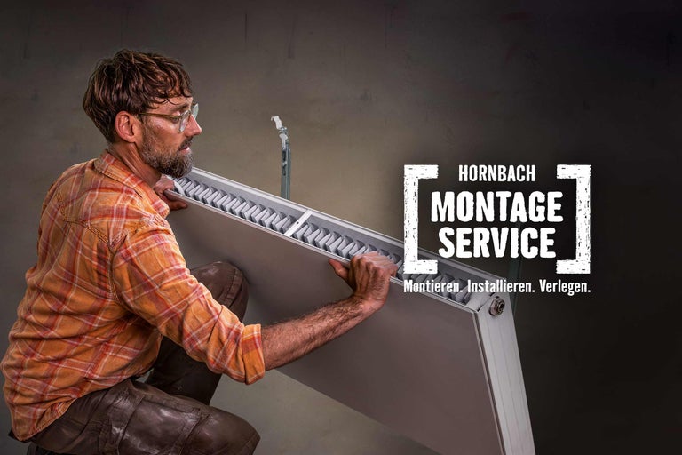 Ein Handwerker montiert einen Heizkörper. Hornbach Montageservice