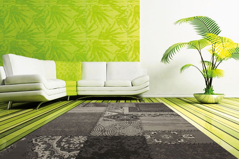 Wohnzimmer mit grauem Teppich, Couch und Pflanze