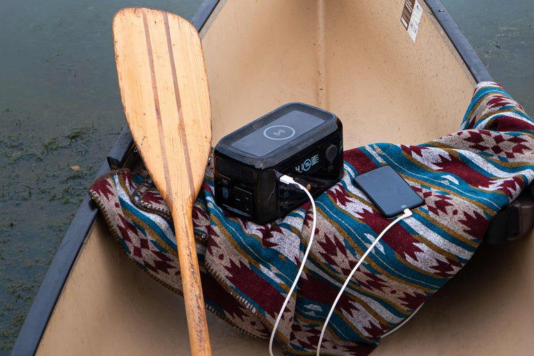 Energiespeicher mit Paddel und Mobiltelefon in einem Kanu