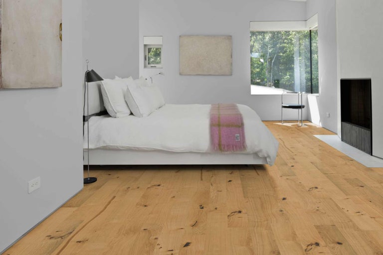 Schlafzimmer mit Holzboden, Bett und Fenster für eine helle und freundliche Atmosphäre.