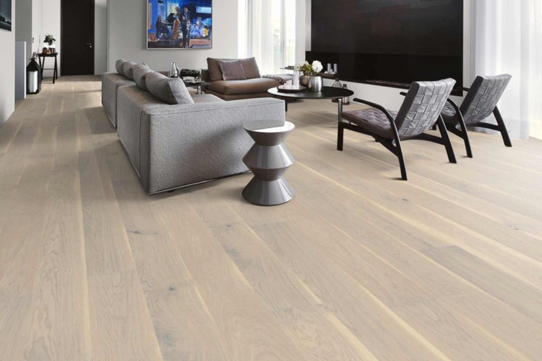 Heller Wohnraum mit Holzboden, Sofa und Sesseln