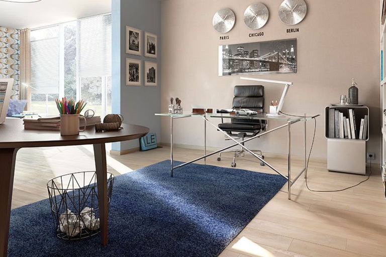 Ein helles Arbeitszimmer mit Schreibtisch, Bürostuhl und Teppich