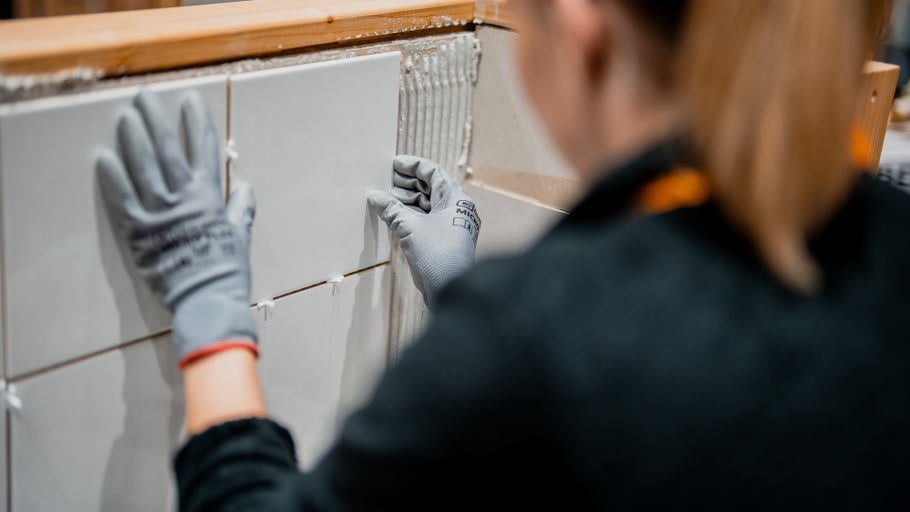 Fliesenleger verlegt Wandfliesen im Innenbereich