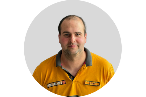 Ein Mitarbeiter von Hornbach trägt ein Poloshirt mit dem Hornbach Logo.