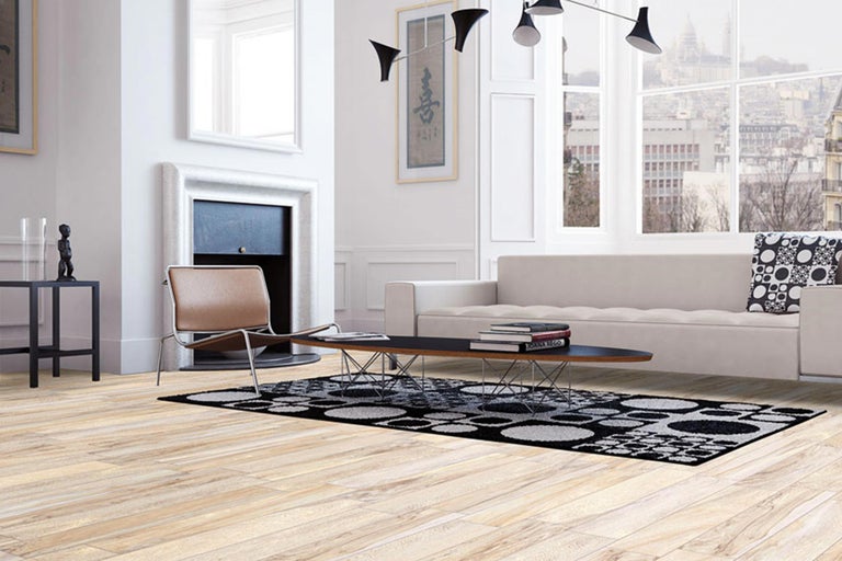 Helles Wohnzimmer mit Sofa, Sessel, Teppich und Holzboden