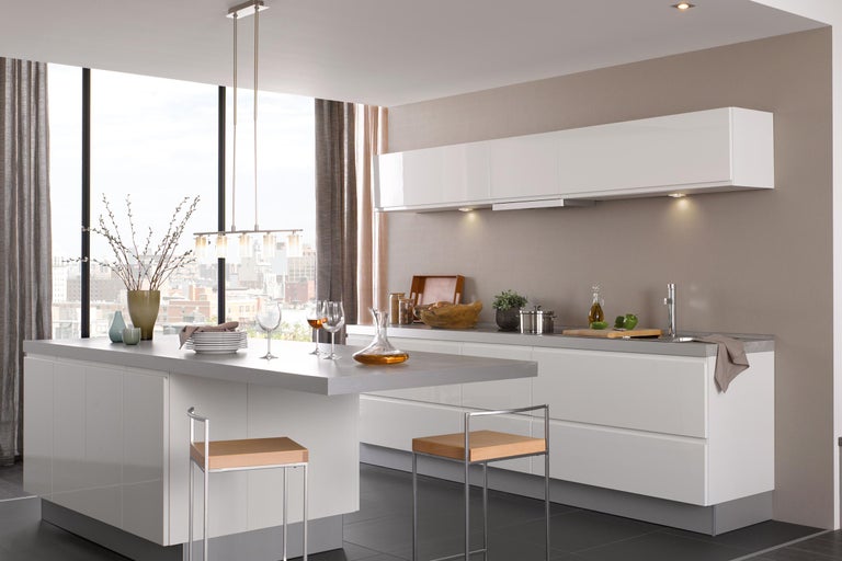 Helle, moderne Küche mit Kücheninsel, Sitzgelegenheiten, Fenstern und dekorativen Elementen.